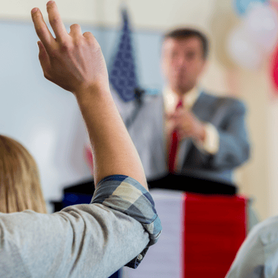 Resident raising a hand at a public meeting